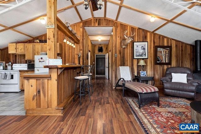 kitchen featuring a breakfast bar, white appliances, kitchen peninsula, and vaulted ceiling