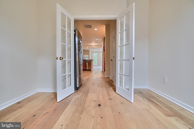 hallway featuring light hardwood / wood-style floors and french doors