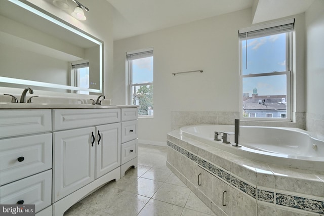 bathroom with tiled tub, vanity, and tile patterned floors