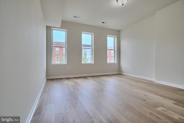 unfurnished room with light hardwood / wood-style floors and a healthy amount of sunlight