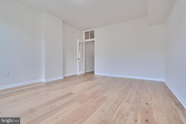 unfurnished room with french doors and light hardwood / wood-style flooring