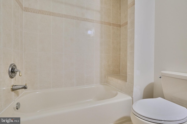 bathroom featuring tiled shower / bath combo and toilet