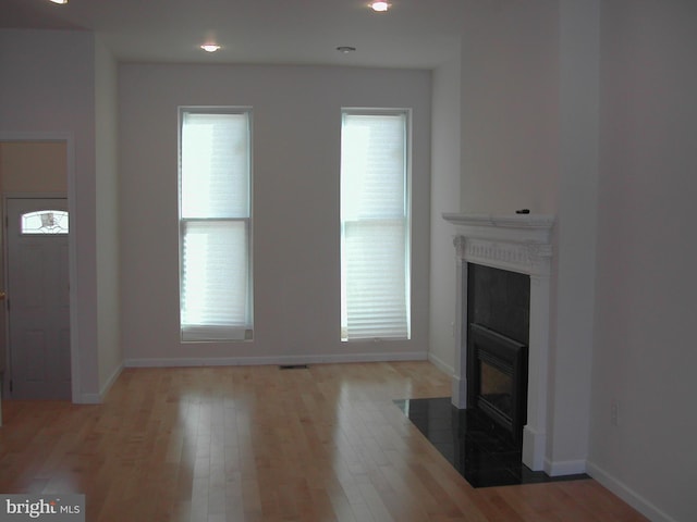 unfurnished living room with a wealth of natural light and hardwood / wood-style floors