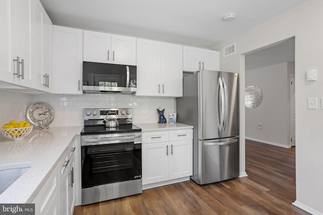 kitchen featuring light stone counters, white cabinets, dark wood-type flooring, and appliances with stainless steel finishes