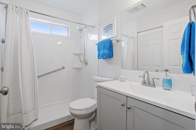 bathroom featuring a shower with shower curtain, vanity, and toilet