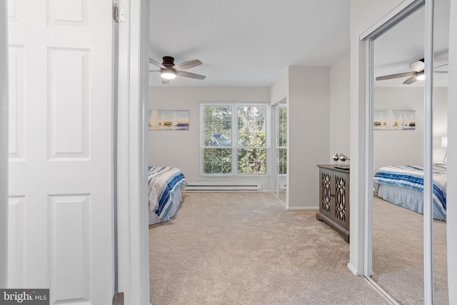 carpeted bedroom with ceiling fan and a baseboard heating unit