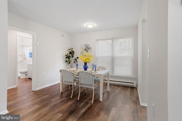 dining room with dark hardwood / wood-style floors and a baseboard heating unit