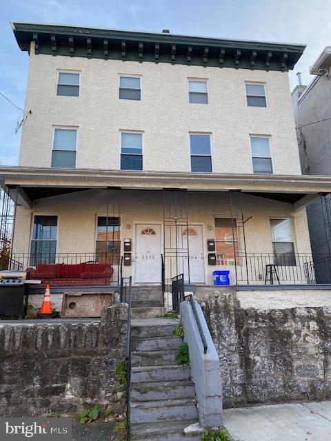 townhome / multi-family property with a porch and stucco siding