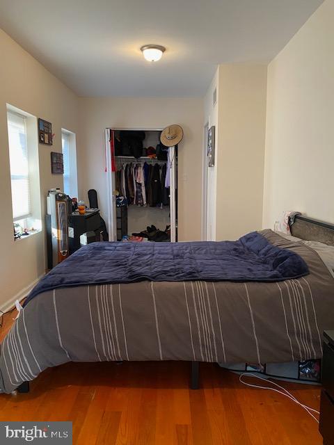 bedroom with wood-type flooring and a closet