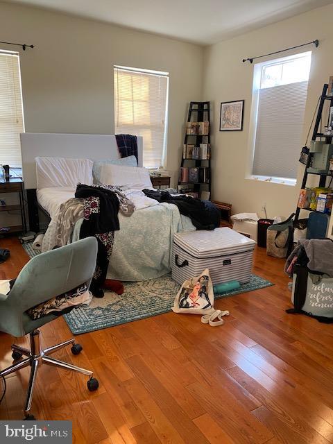 bedroom with hardwood / wood-style flooring and multiple windows