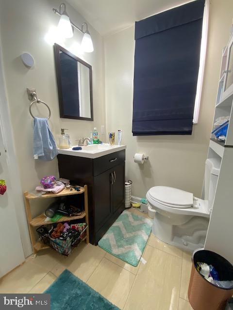 bathroom with toilet, tile patterned floors, and vanity