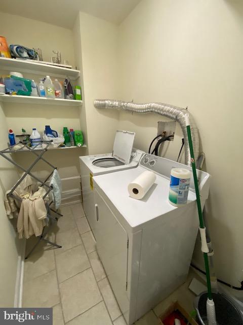 laundry room with washing machine and dryer and light tile patterned flooring