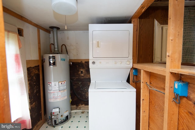 washroom with stacked washer / drying machine and gas water heater