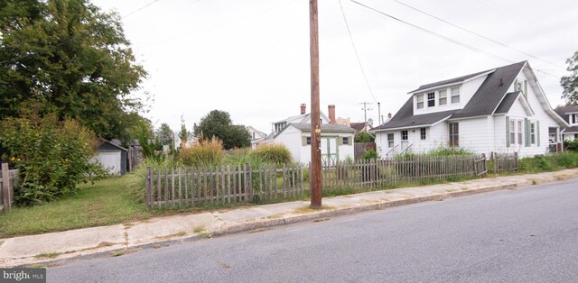 view of front of home with an outbuilding, a fenced front yard, and a storage shed