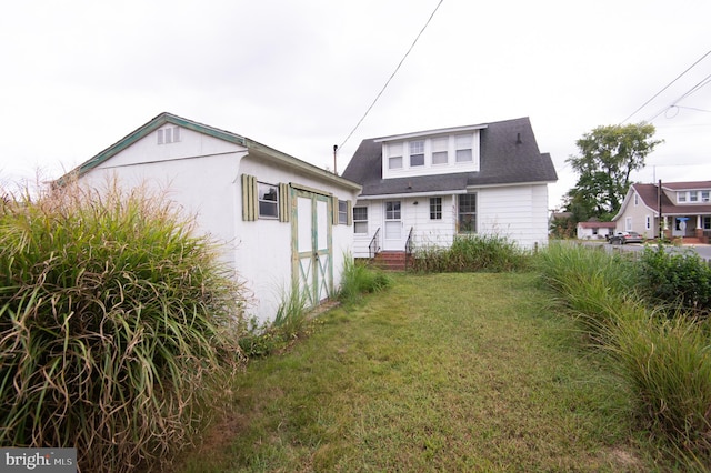 rear view of house featuring a yard