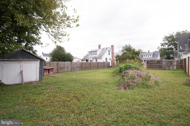 view of yard featuring a fenced backyard, an outdoor structure, and a storage shed