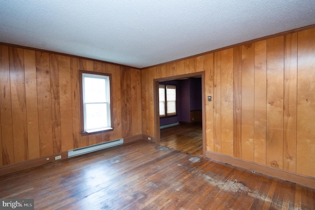 unfurnished room with a baseboard radiator, wood walls, and dark wood-type flooring