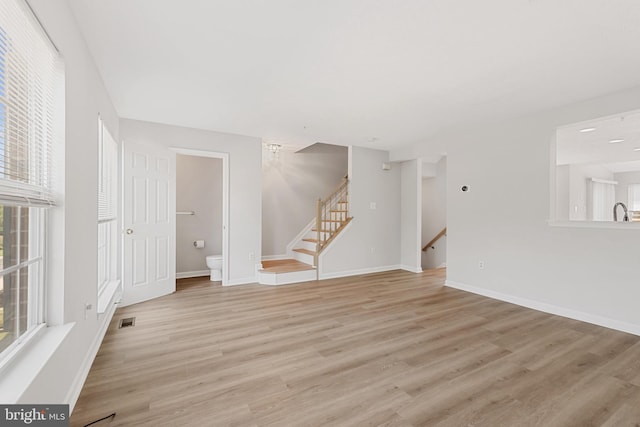 unfurnished living room featuring light hardwood / wood-style flooring and sink