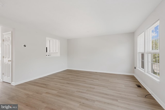 unfurnished room featuring light wood-type flooring and plenty of natural light