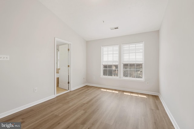 empty room with lofted ceiling and light hardwood / wood-style flooring