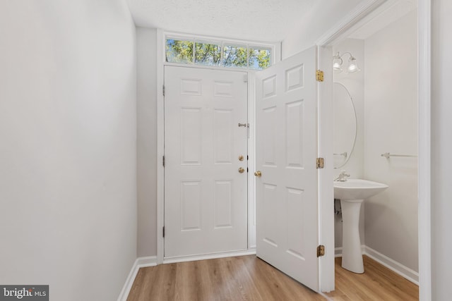 foyer with a textured ceiling and light hardwood / wood-style flooring