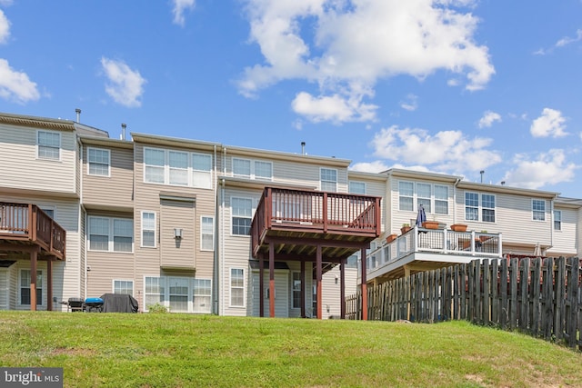 back of house featuring a wooden deck and a yard