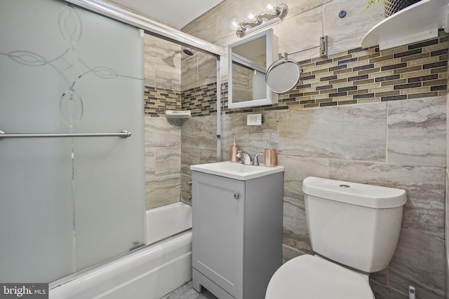 full bathroom with toilet, bath / shower combo with glass door, and vanity