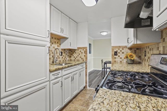 kitchen featuring tasteful backsplash, sink, stainless steel range with gas stovetop, white cabinetry, and ventilation hood