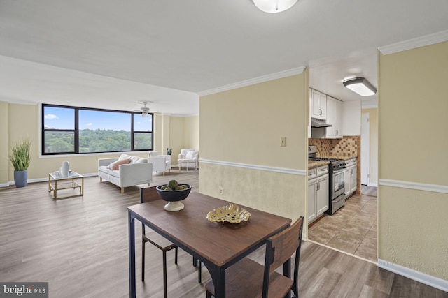 dining space featuring ceiling fan, crown molding, and light hardwood / wood-style flooring