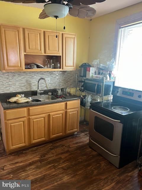 kitchen featuring dark hardwood / wood-style flooring, ceiling fan, range with electric cooktop, and backsplash