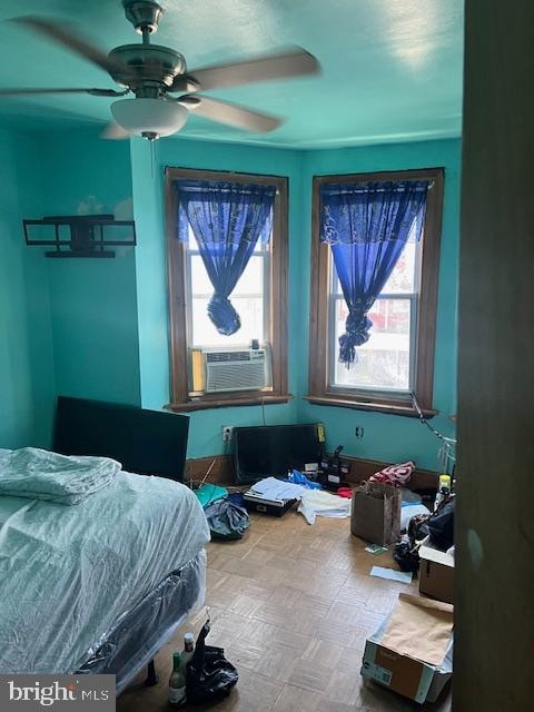 bedroom with cooling unit, ceiling fan, and parquet flooring