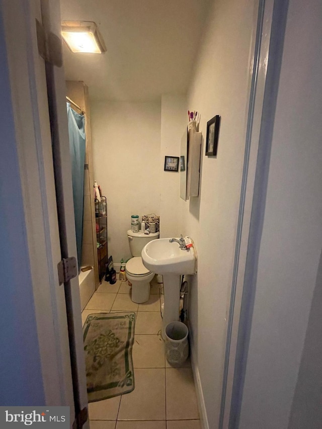 bathroom with tile patterned flooring, a shower with curtain, and toilet