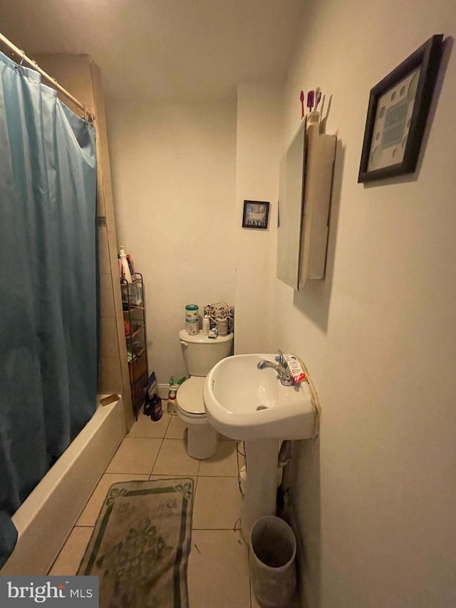 bathroom featuring toilet, sink, and tile patterned flooring