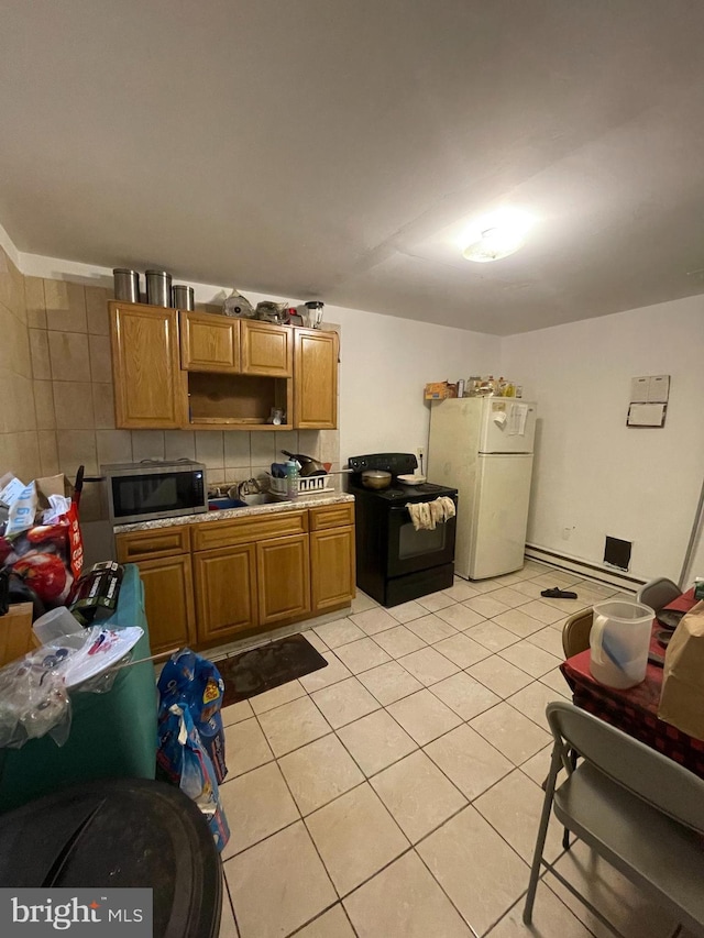 kitchen featuring a baseboard heating unit, black range with electric cooktop, white refrigerator, and light tile patterned flooring