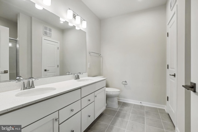 bathroom featuring tile patterned flooring, vanity, toilet, and an enclosed shower