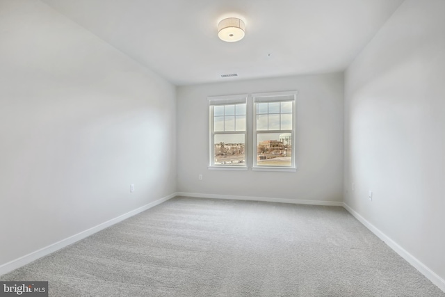 spare room featuring light colored carpet