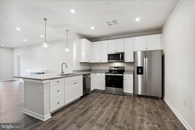 kitchen with white cabinets, appliances with stainless steel finishes, hanging light fixtures, and sink