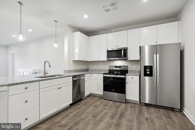 kitchen with pendant lighting, white cabinetry, sink, and appliances with stainless steel finishes