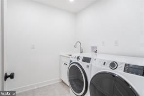 washroom with separate washer and dryer, sink, and cabinets