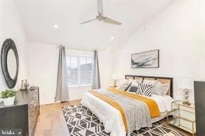 bedroom with ceiling fan, lofted ceiling, and light hardwood / wood-style flooring