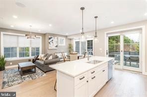 kitchen featuring white cabinetry, dishwasher, sink, pendant lighting, and a center island with sink