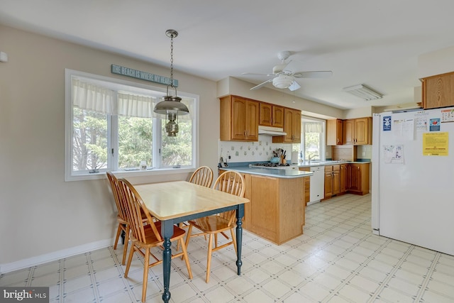 kitchen with tasteful backsplash, ceiling fan, kitchen peninsula, pendant lighting, and white appliances