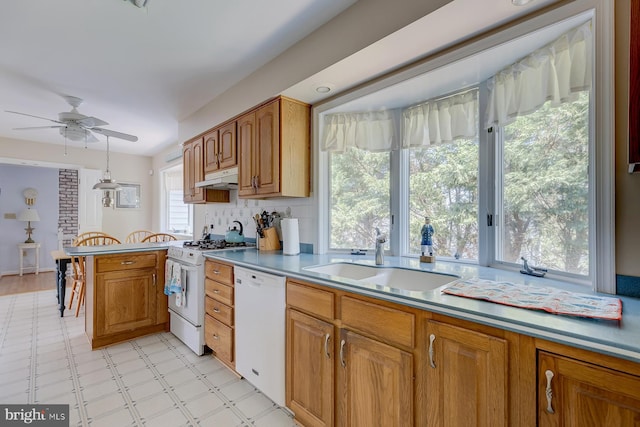 kitchen with sink, white appliances, kitchen peninsula, ceiling fan, and backsplash