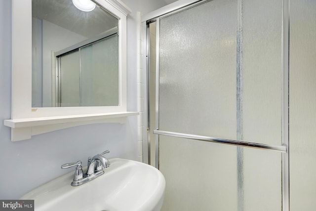 bathroom featuring walk in shower and sink