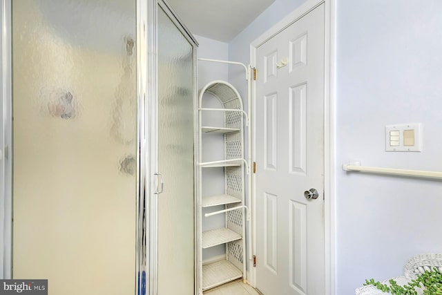 bathroom with tile patterned flooring and a shower with shower door