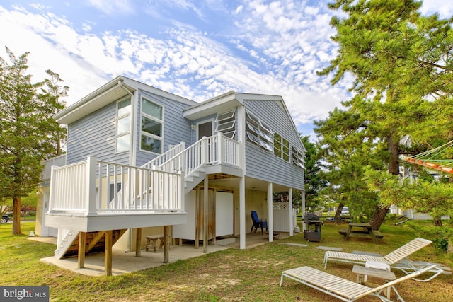 back of property with a patio, a yard, and a deck