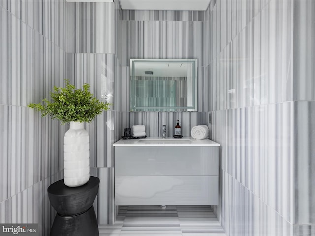 bathroom featuring vanity and tile walls