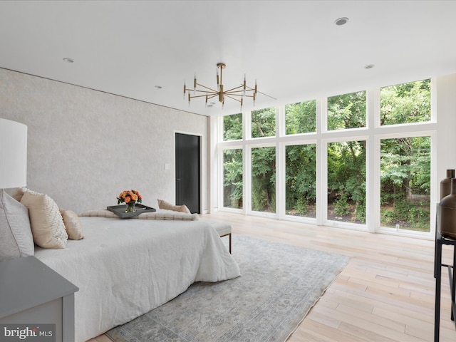 bedroom with a chandelier and light hardwood / wood-style flooring