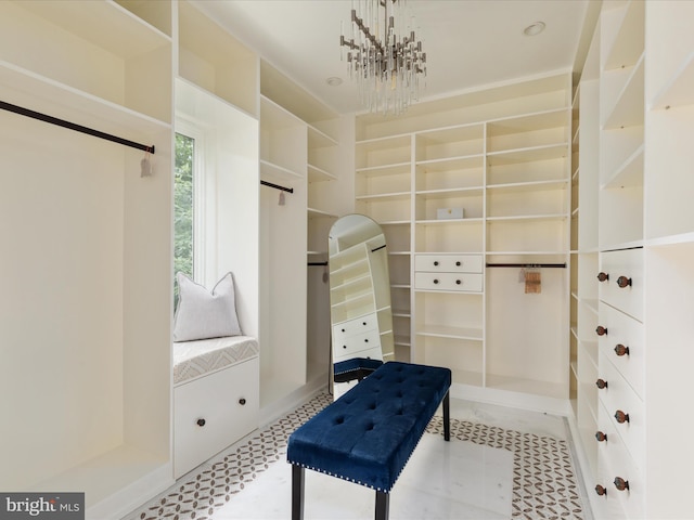 walk in closet with an inviting chandelier