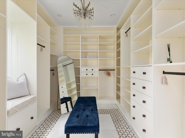 walk in closet featuring a chandelier